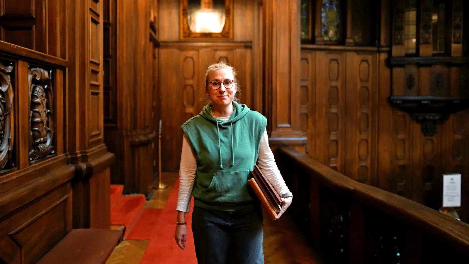 Lara Klewin in einem holzvertäfelten Treppenhaus
